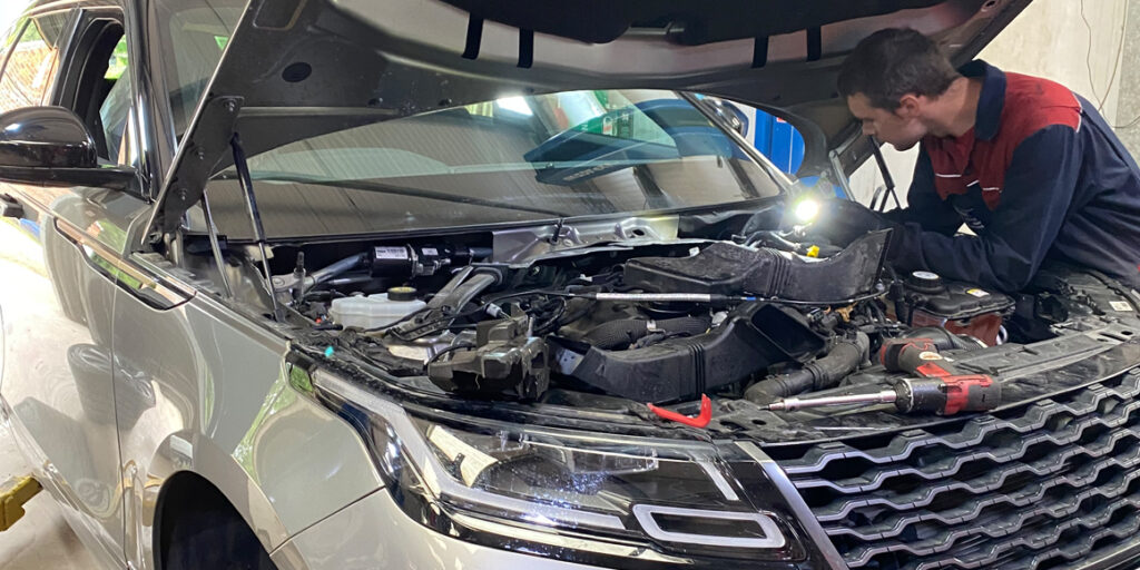 mechanic working under the bonnet